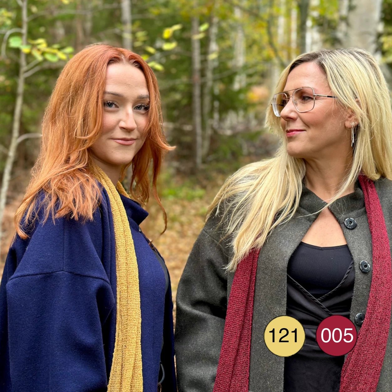 Två kvinnor sida vid sida utomhus, den ena i en Almira sjal i ljus senap och den andra i vinröd; de finstickade sjalarna visar hur två toner kan bäras tillsammans. Ulla Jacobsson Kläder