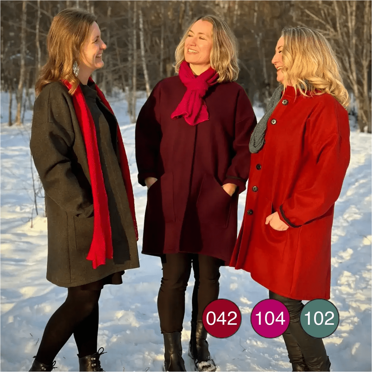 Tre kvinnor tillsammans, var och en i en Almira sjal i olika färg – röd, fuchsia och buteljgrön; bilden visar hur de finstickade sjalarna ser ut i flera toner samtidigt. Ulla Jacobsson Kläder