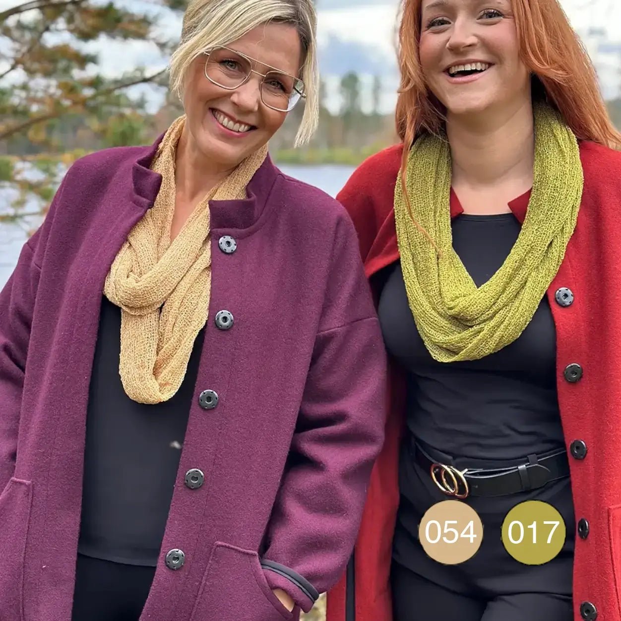 Två kvinnor utomhus i finstickade Sally tubsjalar – en kamelfärgad och en olivgrön – virade runt halsen över höstkappor; den stora tubsjalen syns i två varma toner. Ulla Jacobsson Kläder